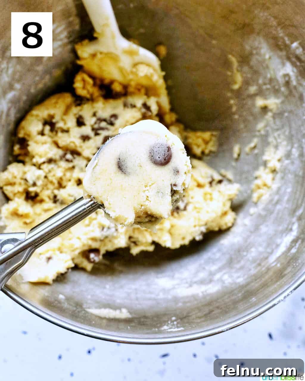 Crispy Air-Fried Delights 15 cookie scoop filled with cookie dough over a stand mixer bowl with cookie dough batter.