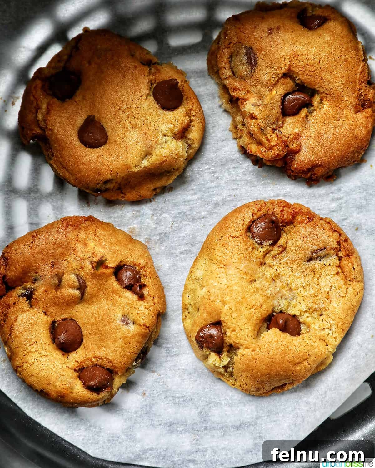 Crispy Air-Fried Delights 3 four chocolate chip cookies baked in an air fryer basket.