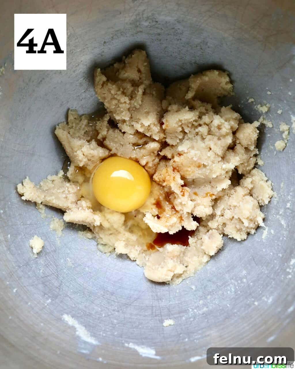 Crispy Air-Fried Delights 9 egg added to cookie dough batter in a stainless steel bowl.
