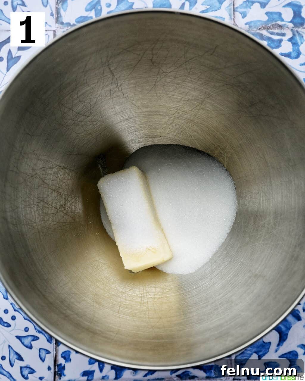 Creaming butter and sugar together in a stainless steel mixing bowl.