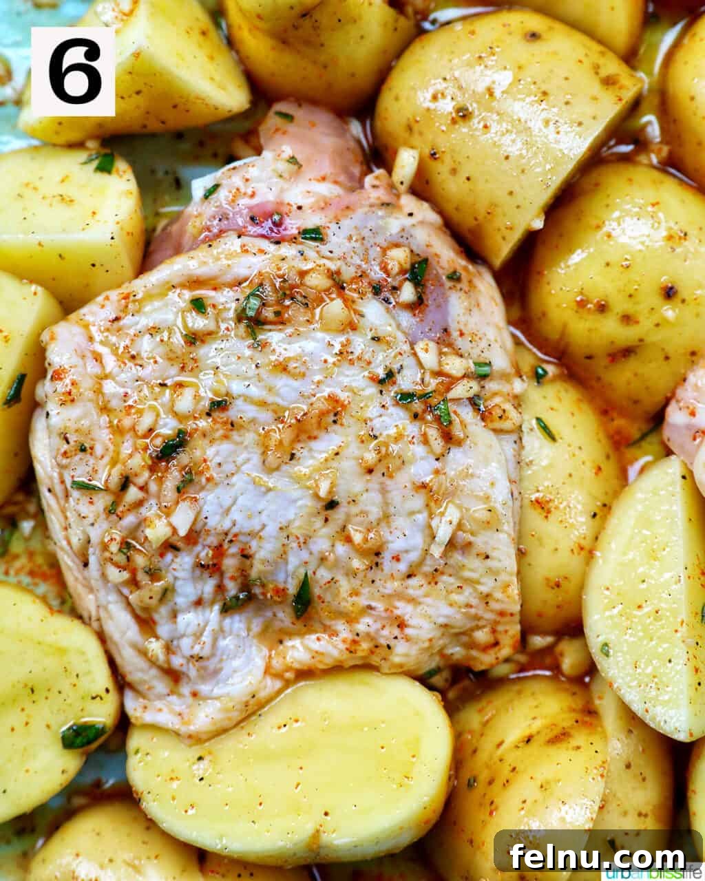 Tek Tepside Tavuklu Patates 11 seasoned raw chicken and sliced potatoes.
