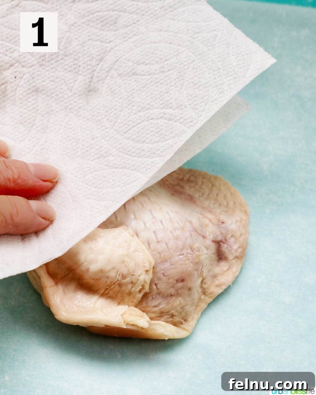 Tek Tepside Tavuklu Patates 5 hand patting raw chicken with a paper towel.