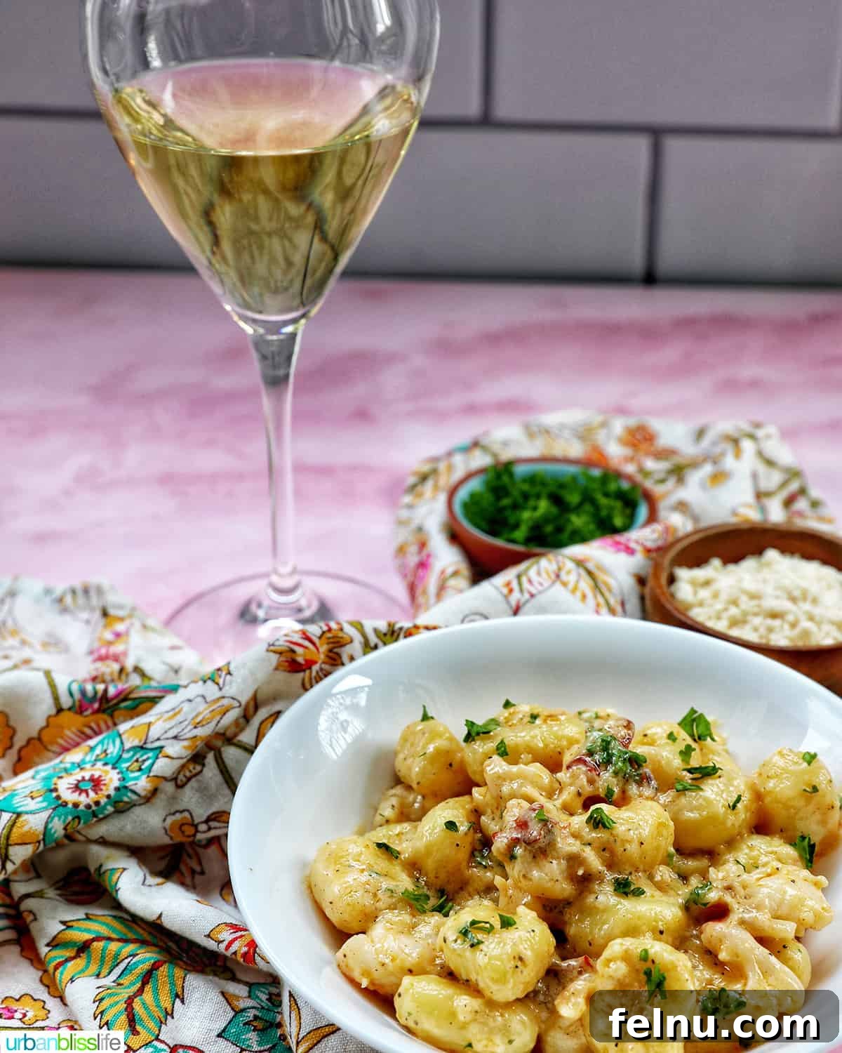 Glass of white wine with a bowl of lobster gnocchi.