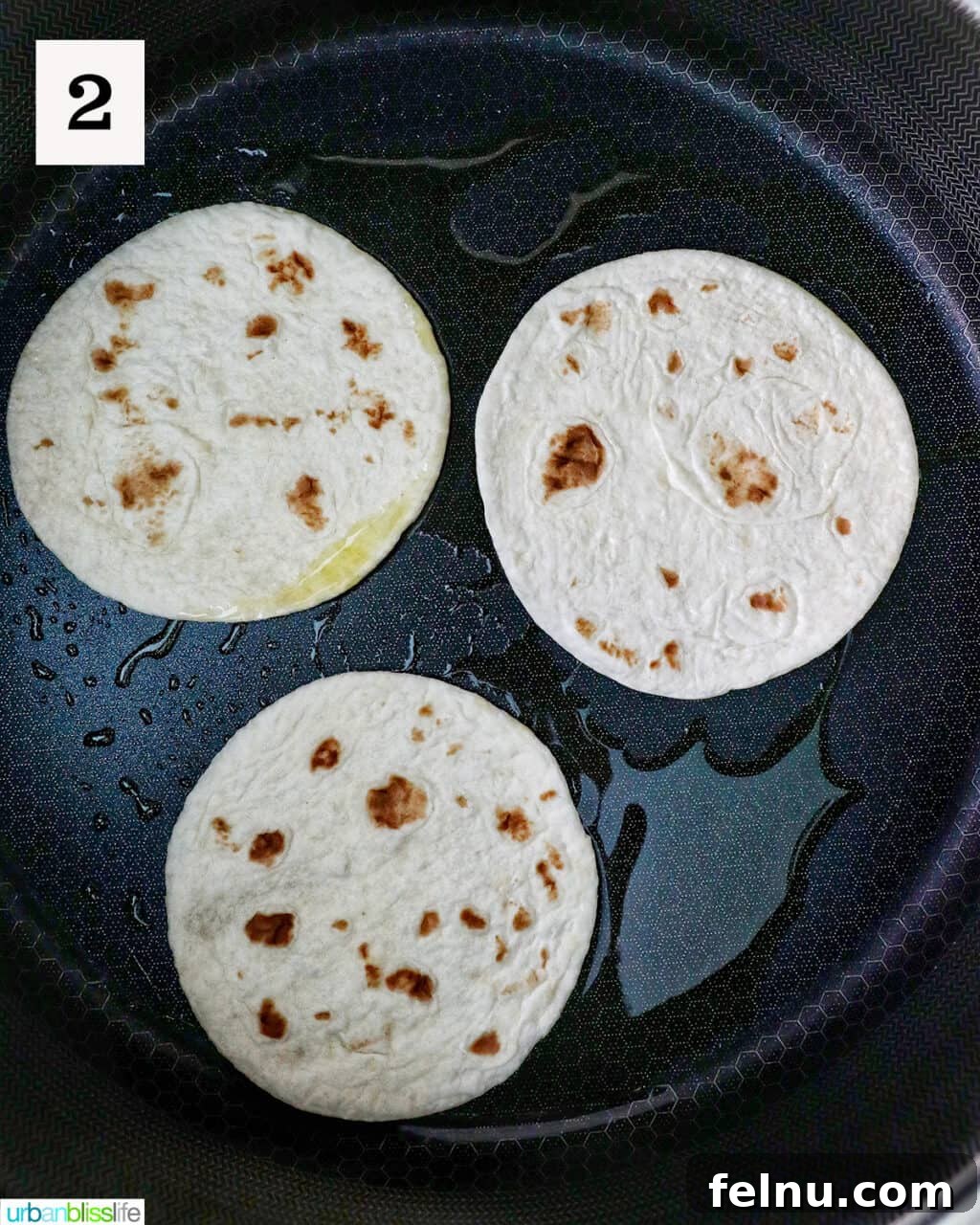 Tortillas toasting in a pan.
