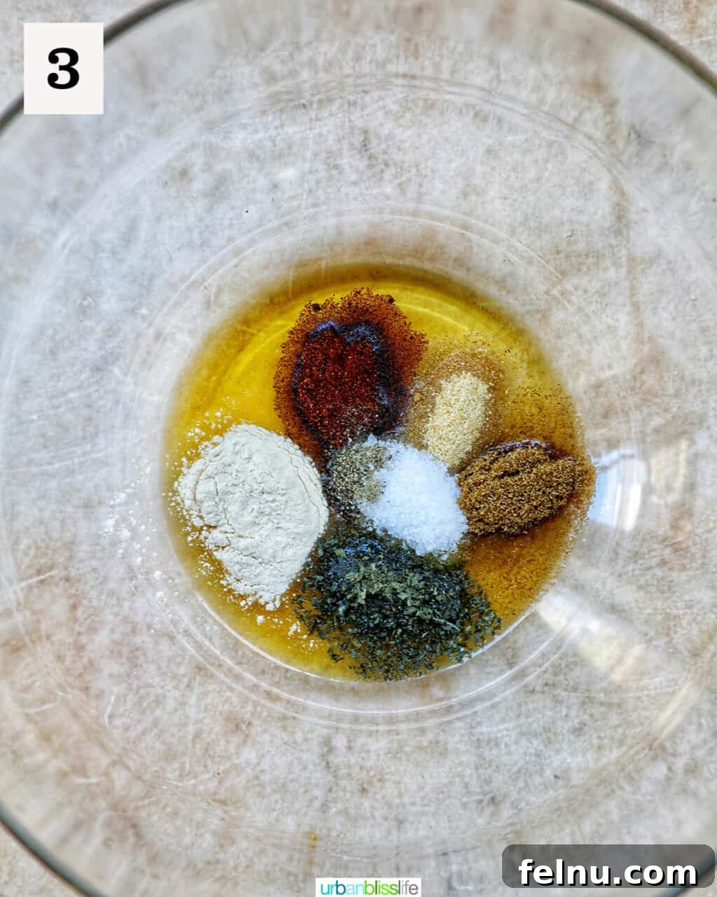 Mixing spices and oil in a bowl.
