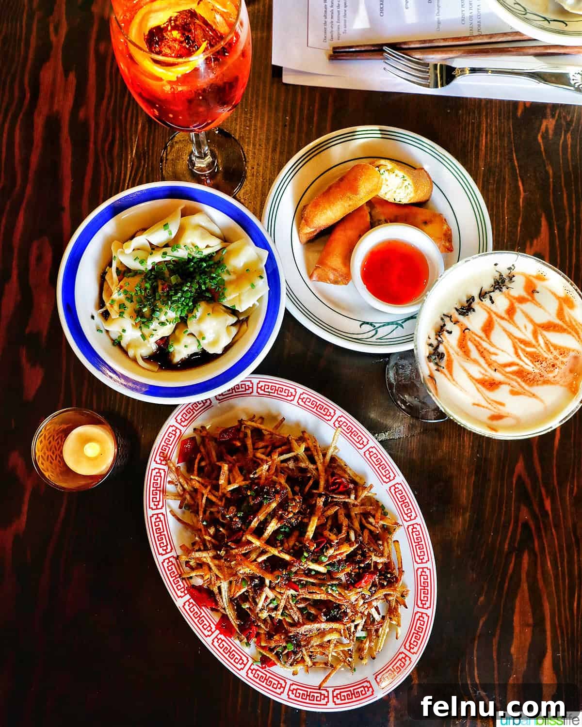 Warsugai Restaurant 2 An overhead shot showcasing a variety of colorful and tempting dishes on a wooden table at Warsugai restaurant, including crispy chicken, noodles, and vibrant sauces.