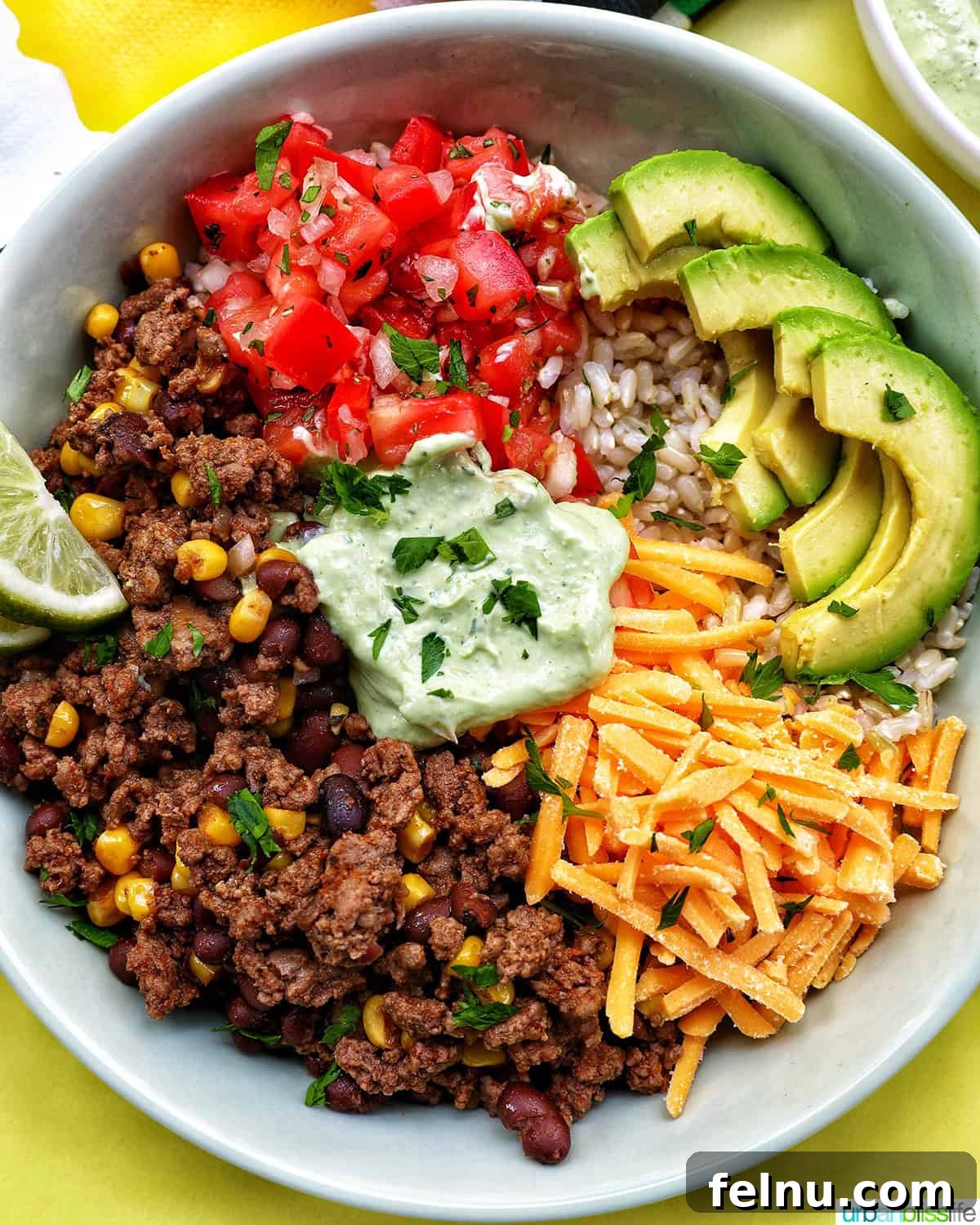 Effortless Fiesta Bowls 2 Taco bowl with ground beef, beans, cheese, pico de gallo, avocado, rice, and avocado cilantro lime crema.