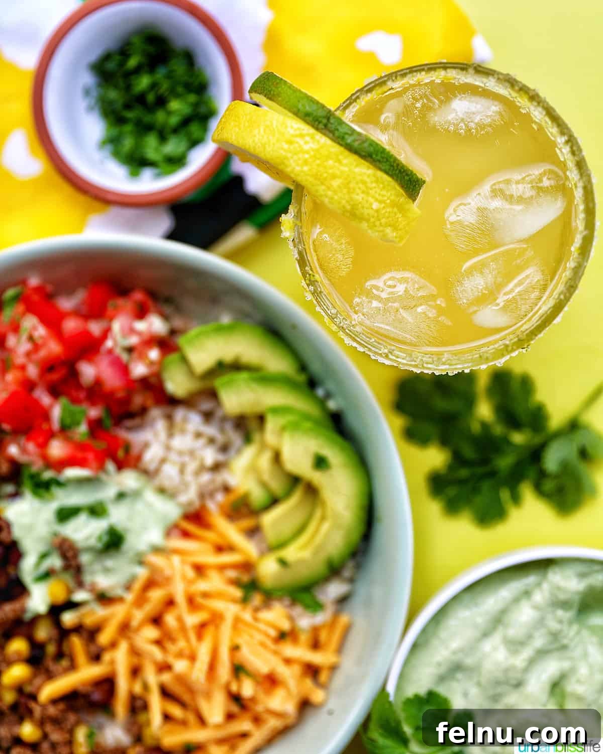 Effortless Fiesta Bowls 16 Taco bowl with a glass of yuzu margarita and garnishes.