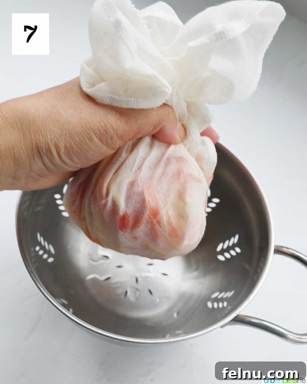 Filipino Atchara: Sweet and Sour Papaya Pickle 11 A hand gently squeezing excess liquid from the vegetables wrapped in a cheesecloth.