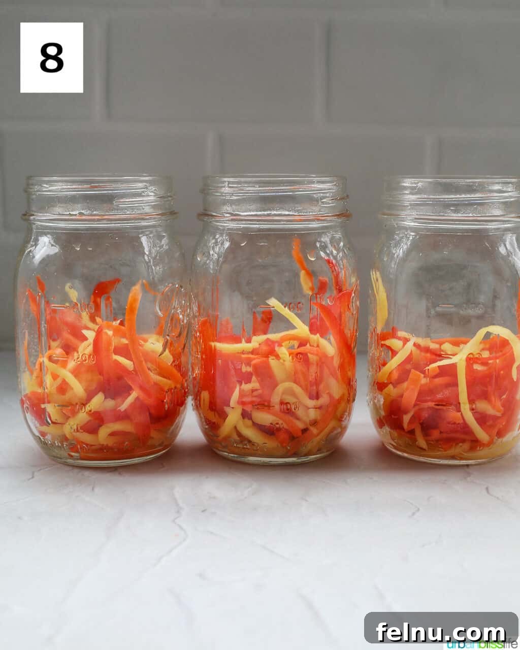 Filipino Atchara: Sweet and Sour Papaya Pickle 12 Mason jars neatly filled with the squeezed vegetables, ready for the pickling liquid.