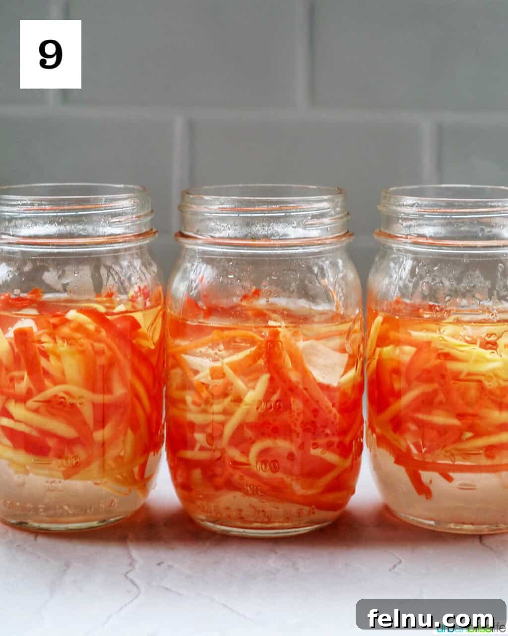 Filipino Atchara: Sweet and Sour Papaya Pickle 13 Pouring the pickling liquid into mason jars filled with vegetables to create Atchara.