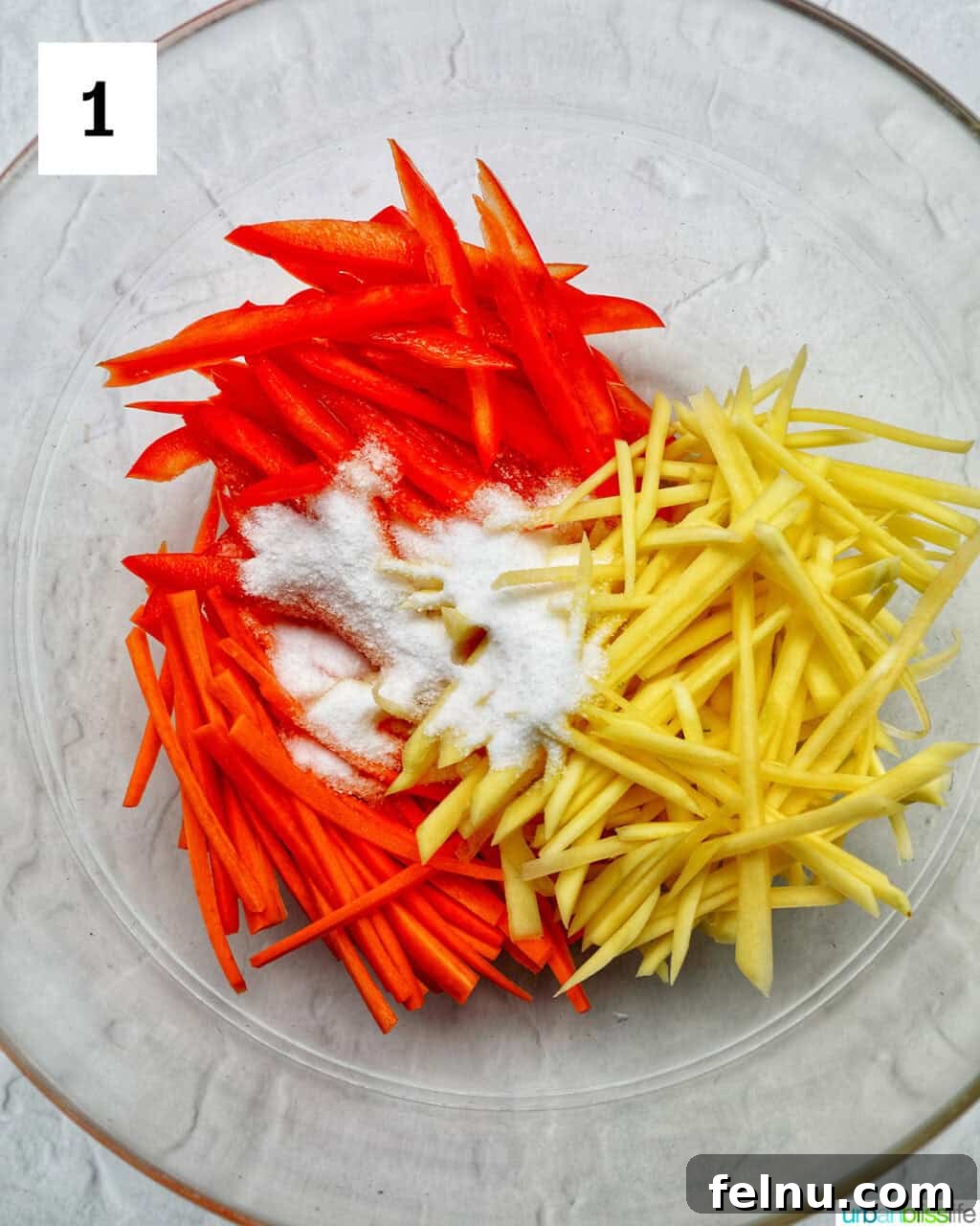 Filipino Atchara: Sweet and Sour Papaya Pickle 5 Sliced papaya, carrots, and red bell pepper in a bowl with salt, preparing for brining.
