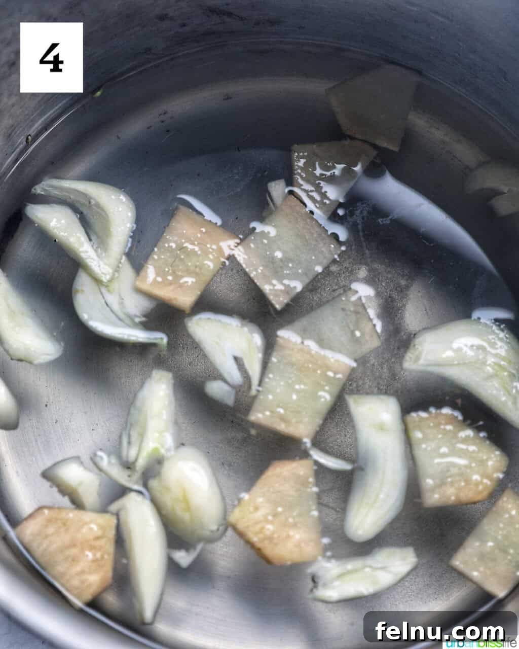 Filipino Atchara: Sweet and Sour Papaya Pickle 8 Thinly sliced garlic and ginger added to the simmering pickling liquid in a pot.