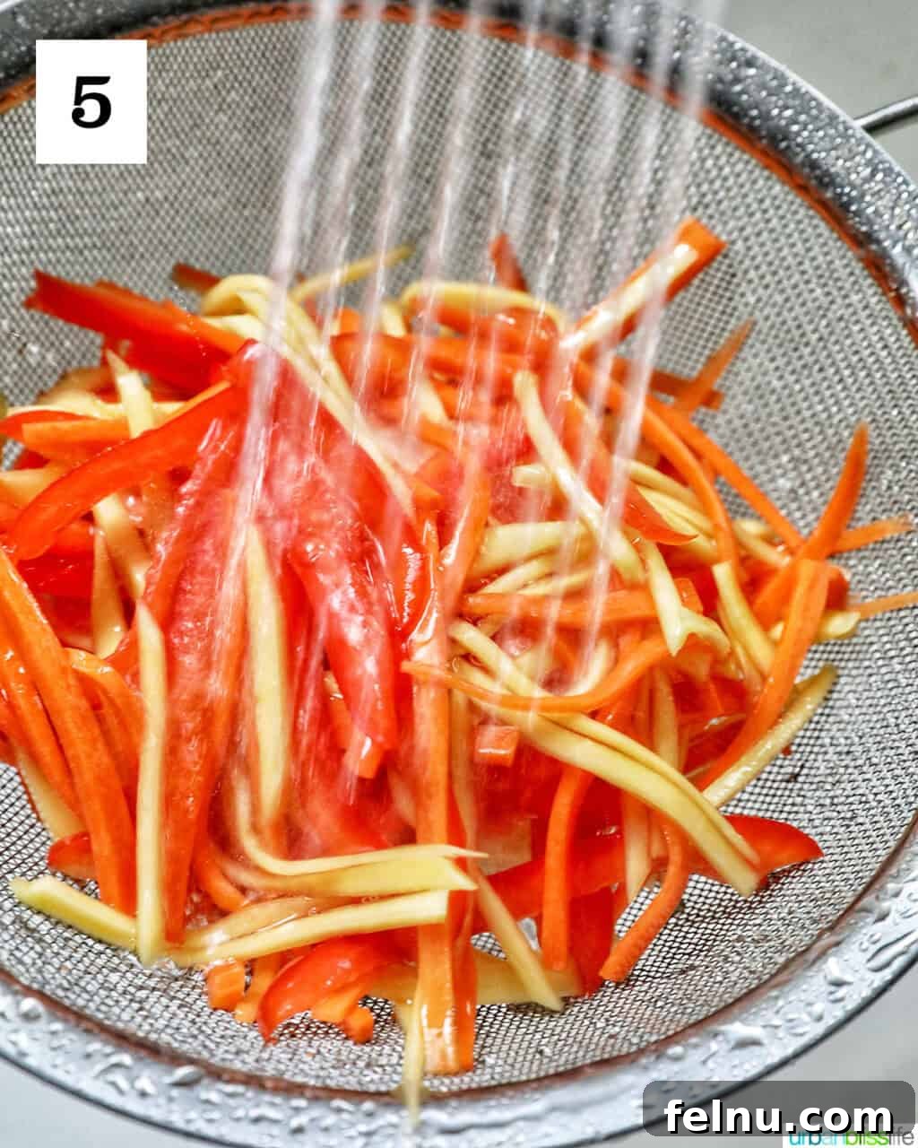 Filipino Atchara: Sweet and Sour Papaya Pickle 9 Rinsing the brined papaya, carrots, and bell pepper under cold running water in a strainer.
