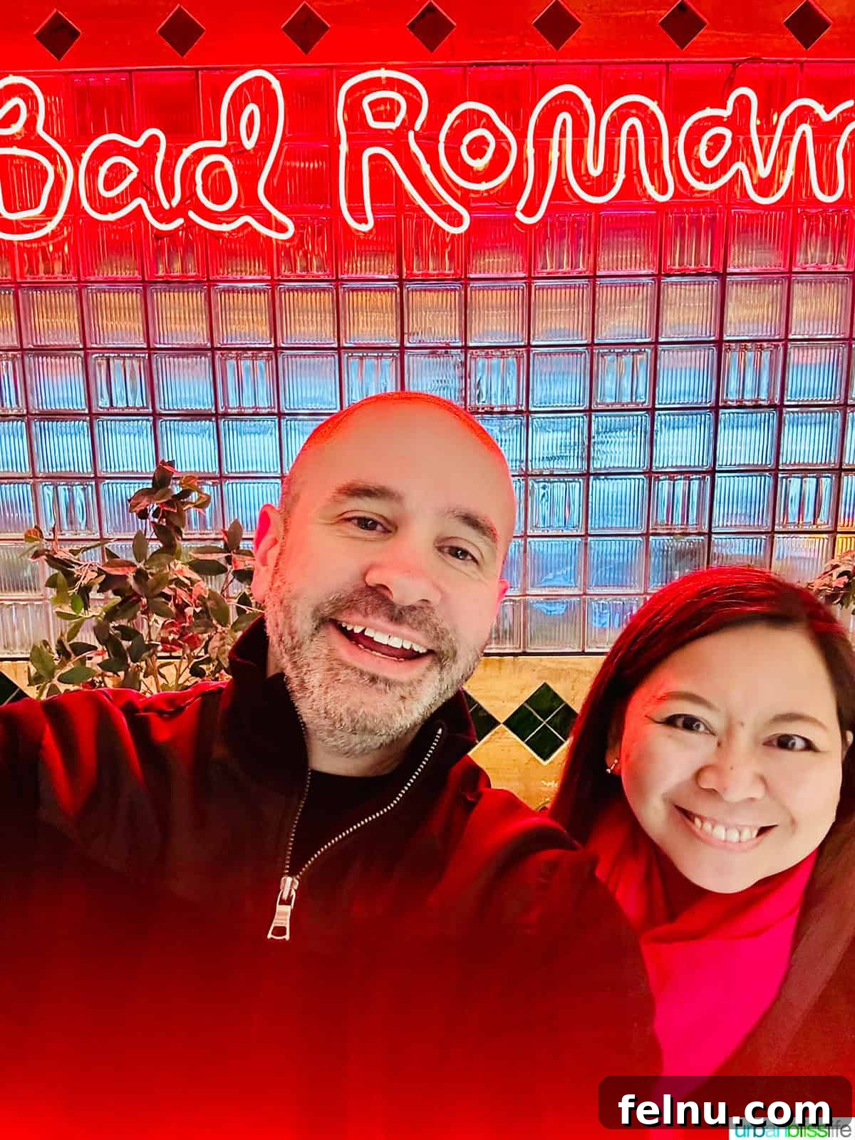 Couple in front of Bad Roman NYC neon sign