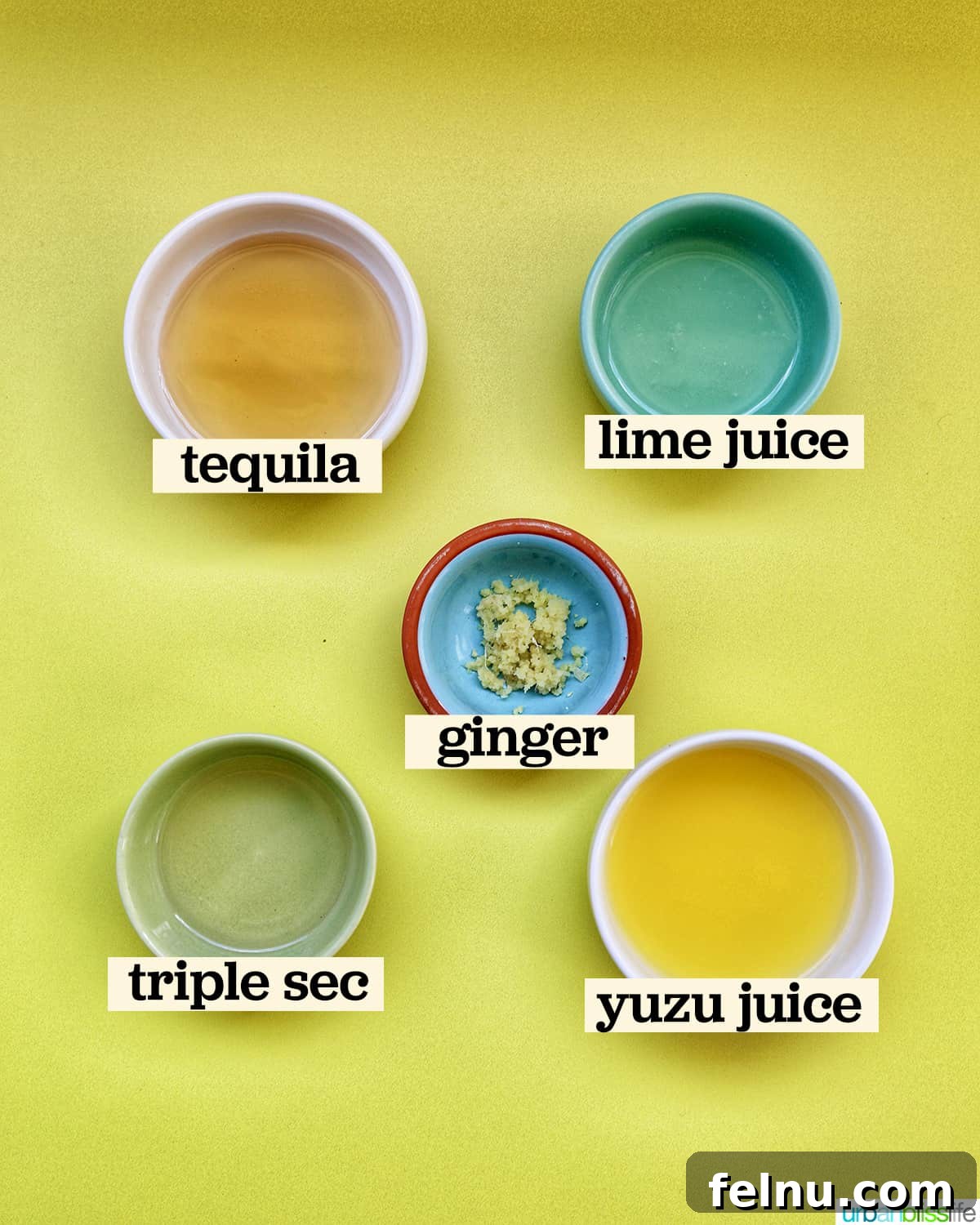 Zesty Yuzu Margarita 5 A collection of fresh ingredients laid out in bowls, including yuzu juice, tequila, triple sec, lime, and ginger, ready for mixing a Yuzu Margarita.