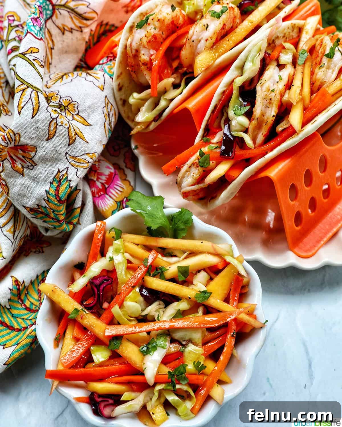 Mango Coleslaw 11 Shrimp tacos on a plate with a side of mango slaw.