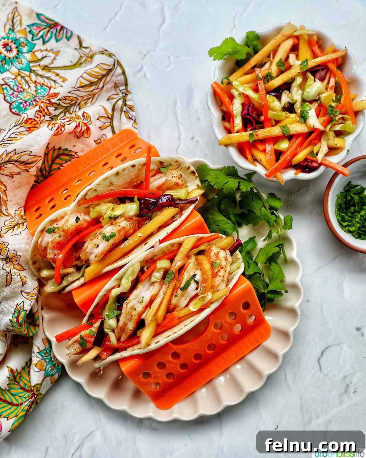 Mango Coleslaw 10 Shrimp tacos on a plate with a side of mango slaw.