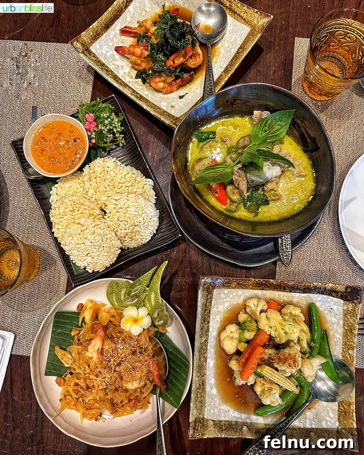 Must-Try Thai Dishes 6 Thai food dishes on a dining table at the Jim Thompson house restaurant in Bangkok, Thailand.