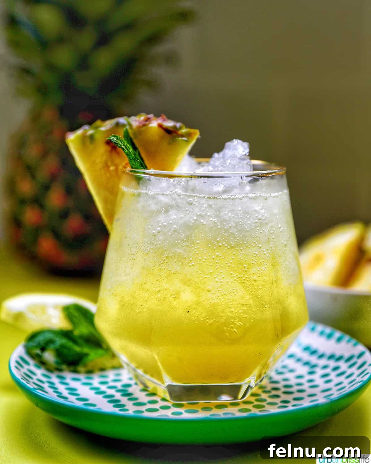 A refreshing glass of Pineapple Mocktail garnished with mint leaves and a pineapple slice.