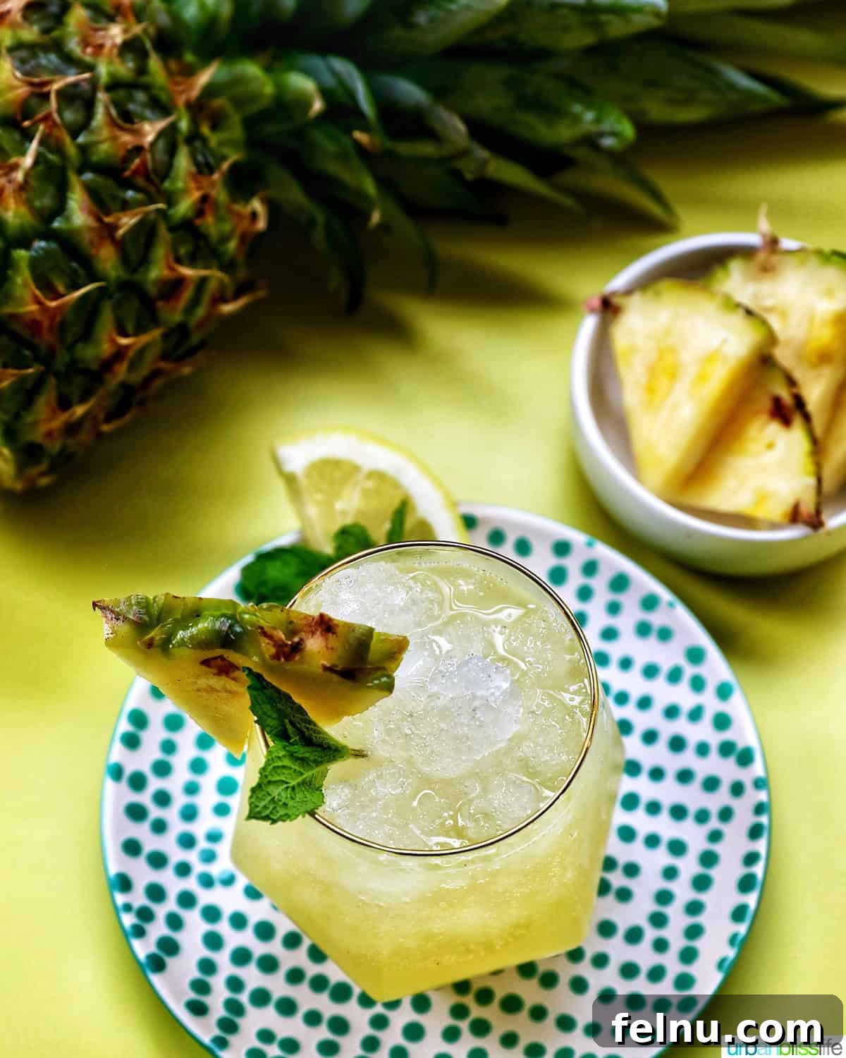 An overhead shot of a Pineapple Mocktail with pineapple slices.