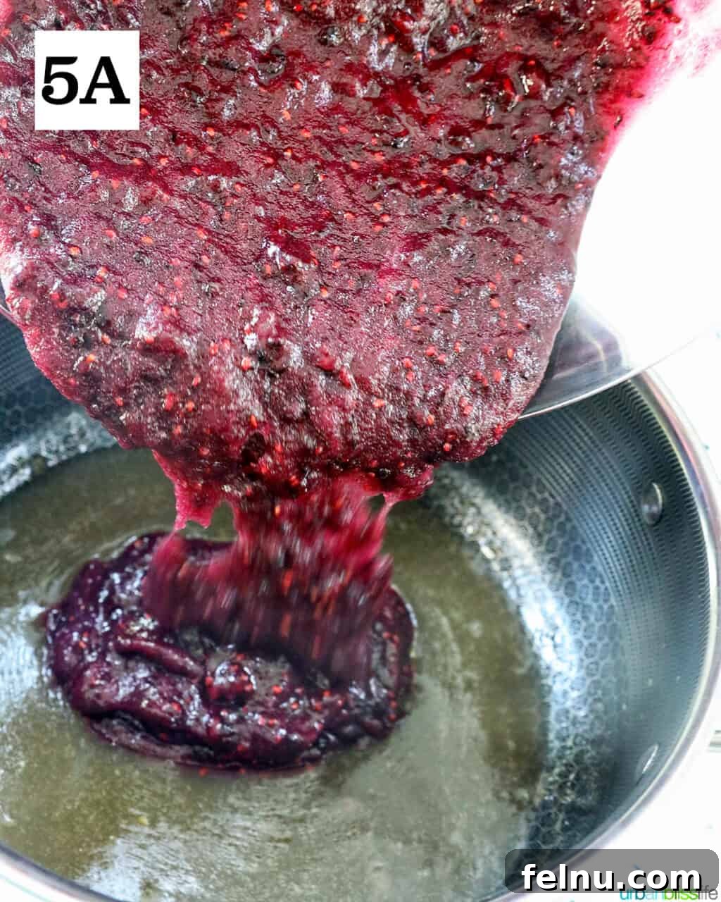 Homemade No-Cook Blackberry Jam 12 adding blackberry mixture to fruit pectin in a saucepan.