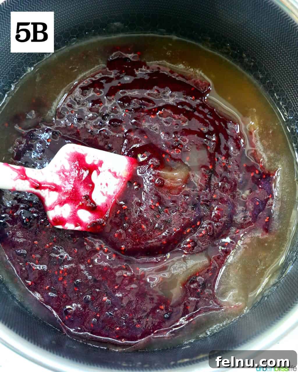 Homemade No-Cook Blackberry Jam 13 spatula mixing blackberry freezer jam in a saucepan.