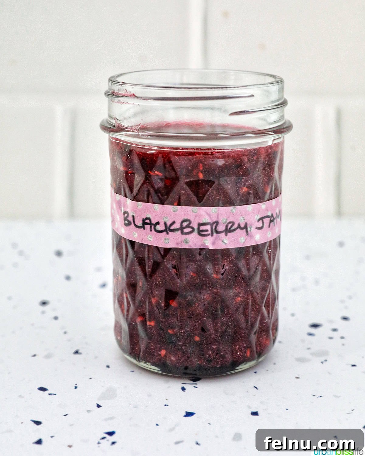 Homemade No-Cook Blackberry Jam 16 mason jar filled with blackberry freezer jam.