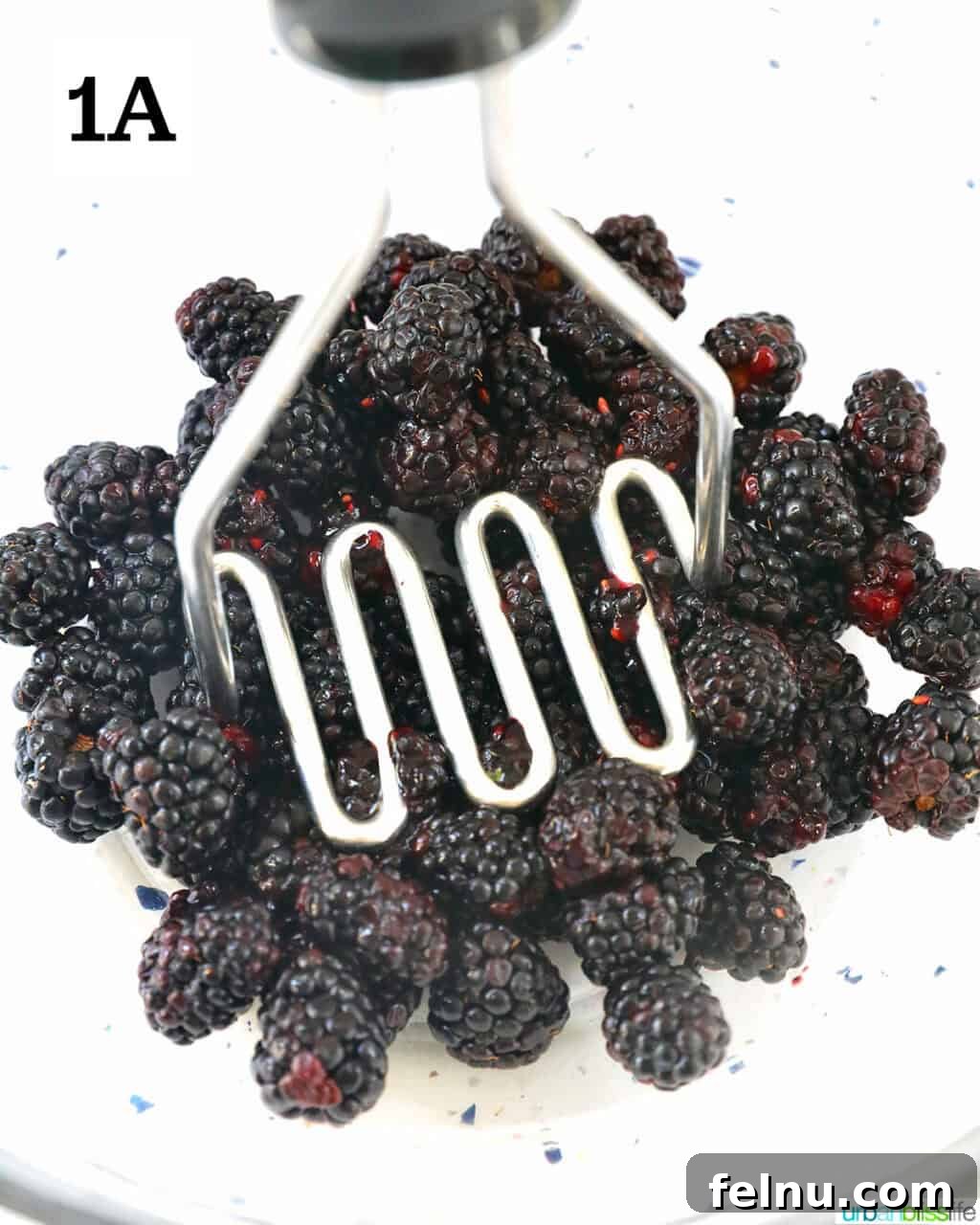Homemade No-Cook Blackberry Jam 6 mashing blackberries to make jam.