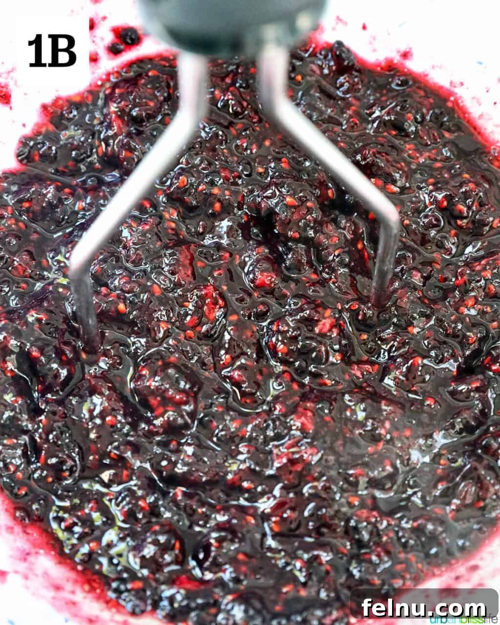 Homemade No-Cook Blackberry Jam 7 mashing blackberries to make jam.