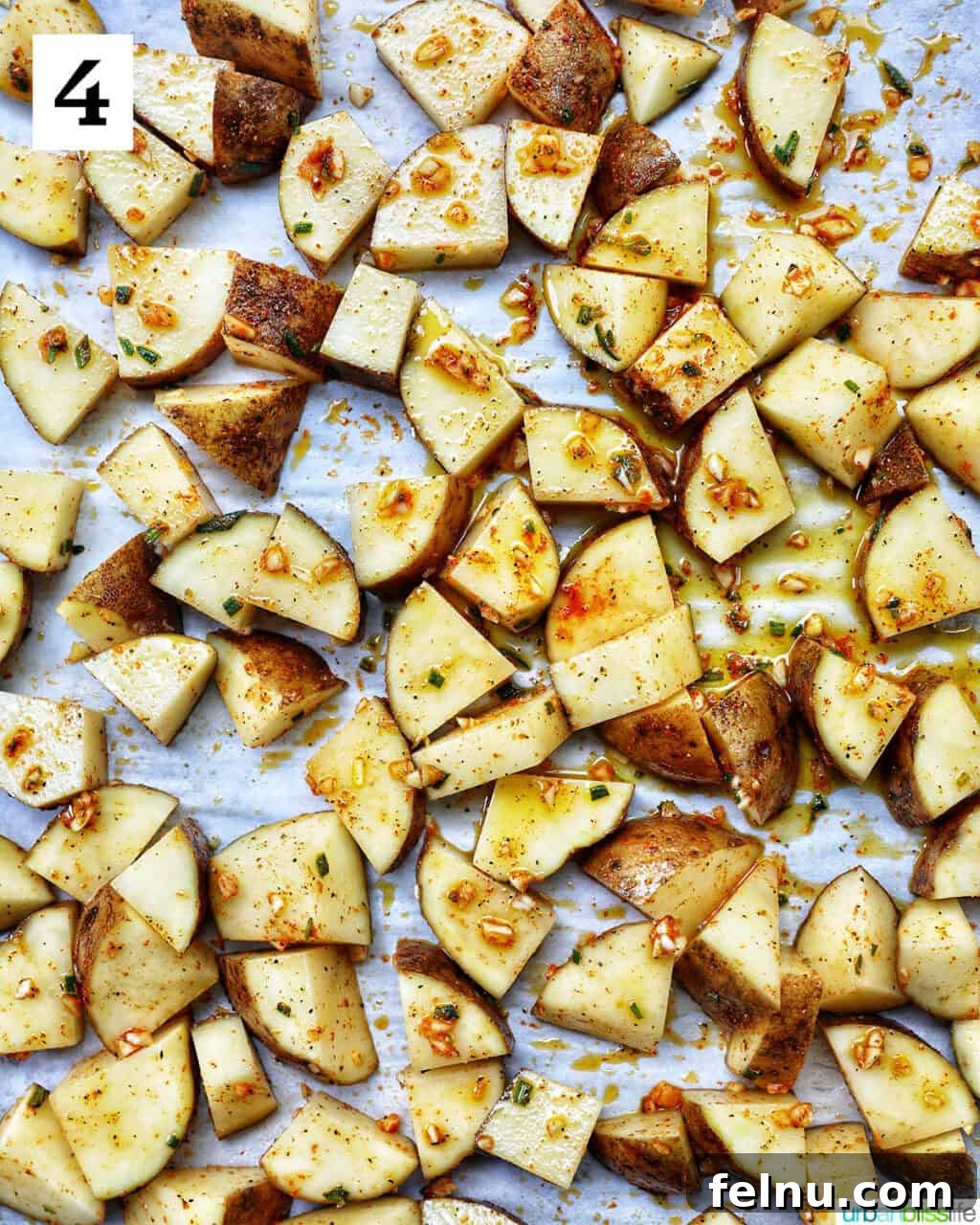 Crispy Rosemary Garlic Potatoes 8 rosemary and garlic roasted potatoes on a baking sheet.