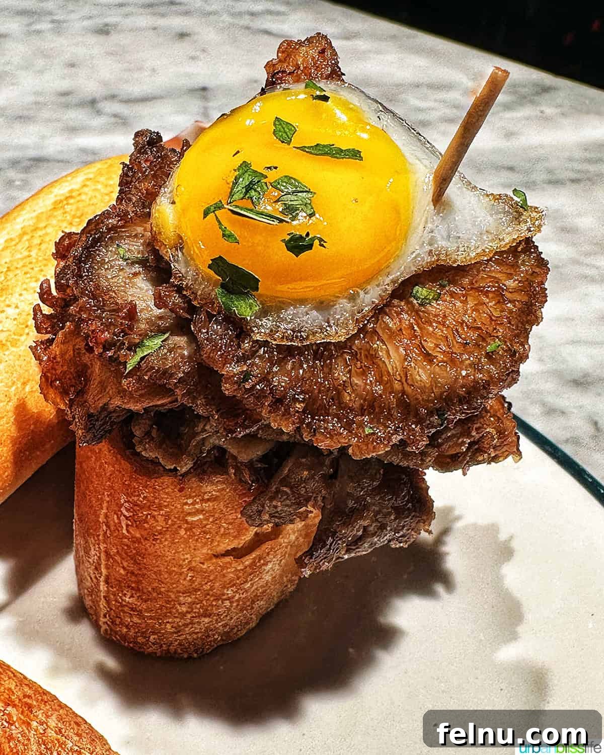 Savoring San Sebastian's Finest Pintxos 3 A delectable pintxo featuring a perfectly cooked egg on top of succulent steak, served on a slice of rustic bread.