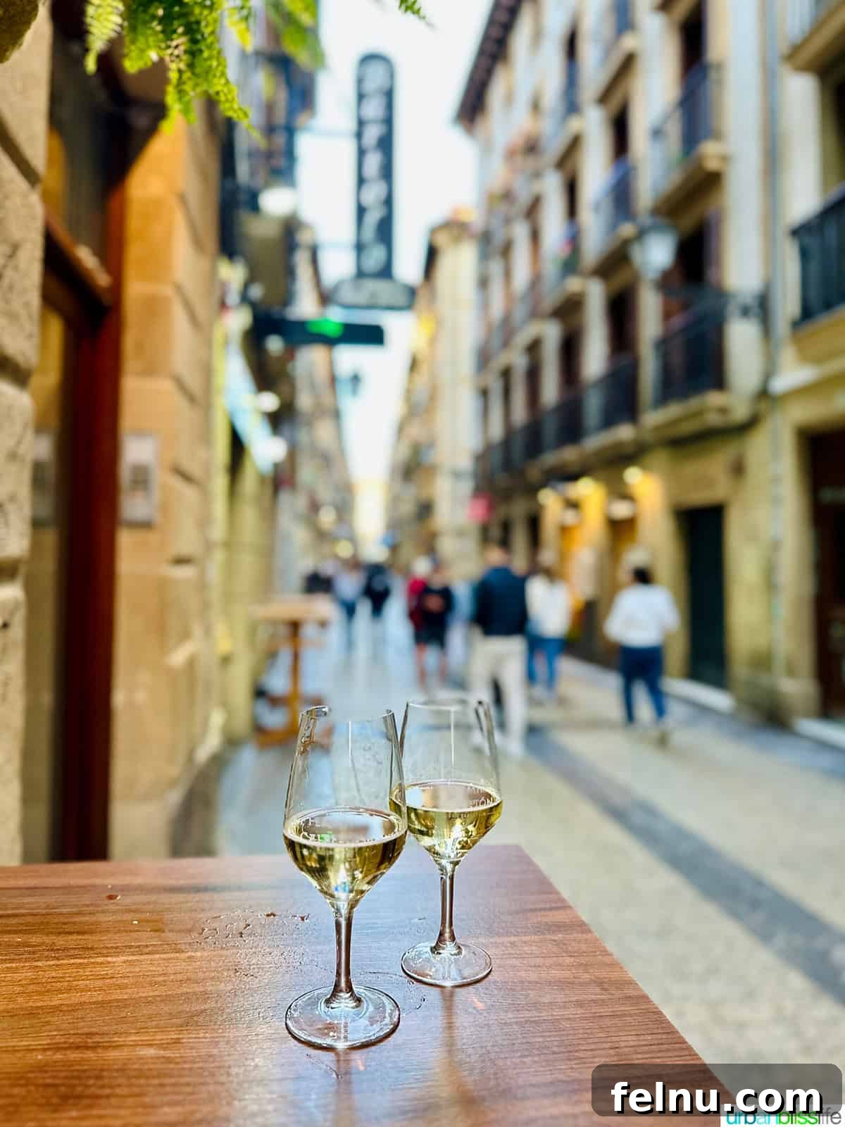 Savoring San Sebastian's Finest Pintxos 4 Two glasses of crisp Txakoli wine elegantly placed on a table in a bustling street of San Sebastian, Spain, ready to be enjoyed with pintxos.