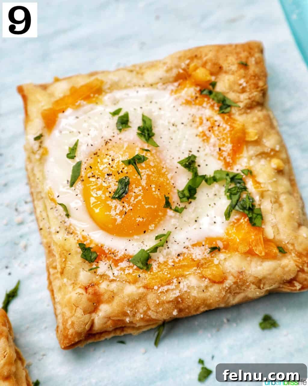 Golden Egg Parcels 15 Final baked eggs in puff pastry on a baking sheet, garnished with fresh parsley.