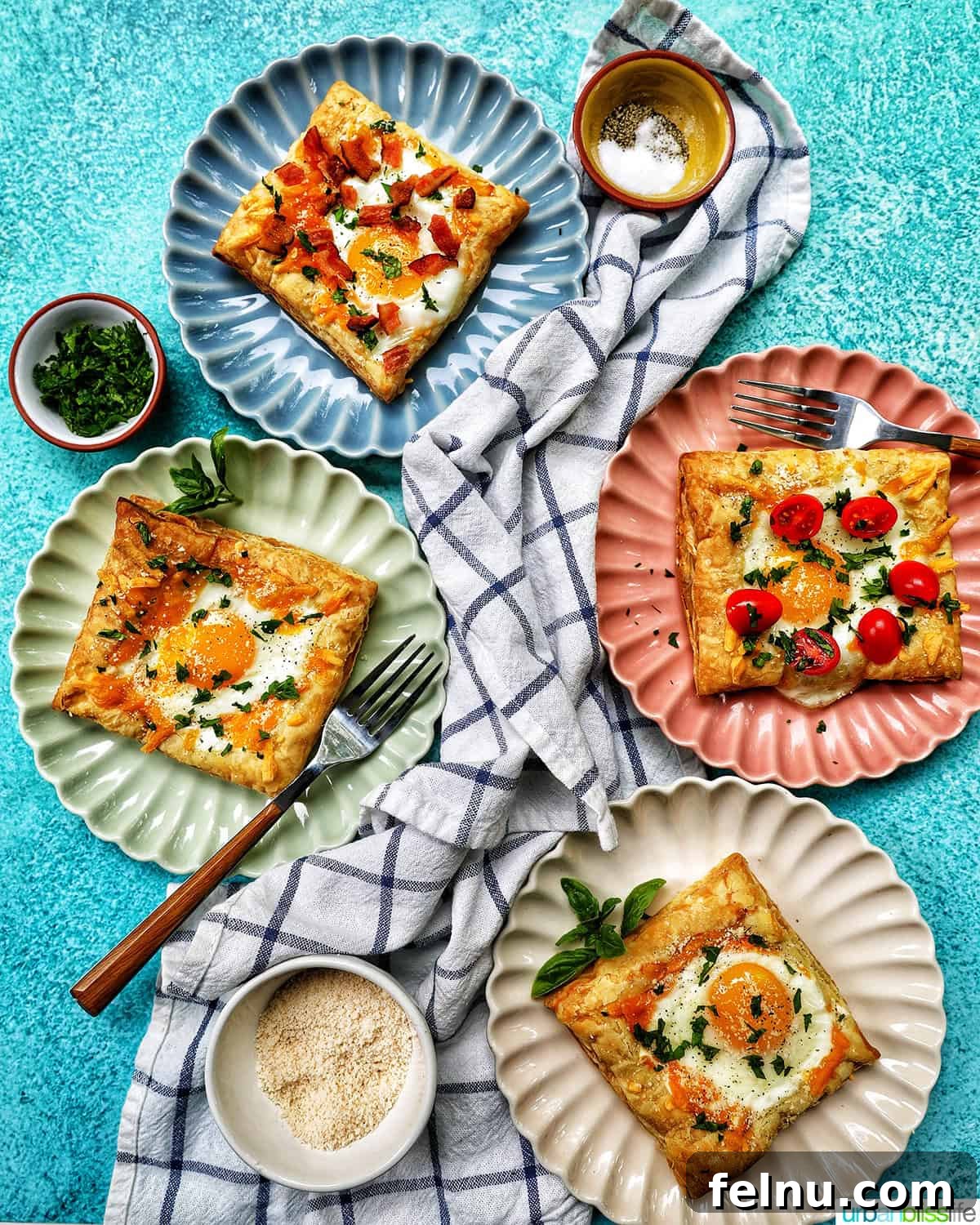 Golden Egg Parcels 17 Multiple plates with eggs in puff pastry, featuring bacon, tomatoes, and parsley garnishes, set with cutlery.