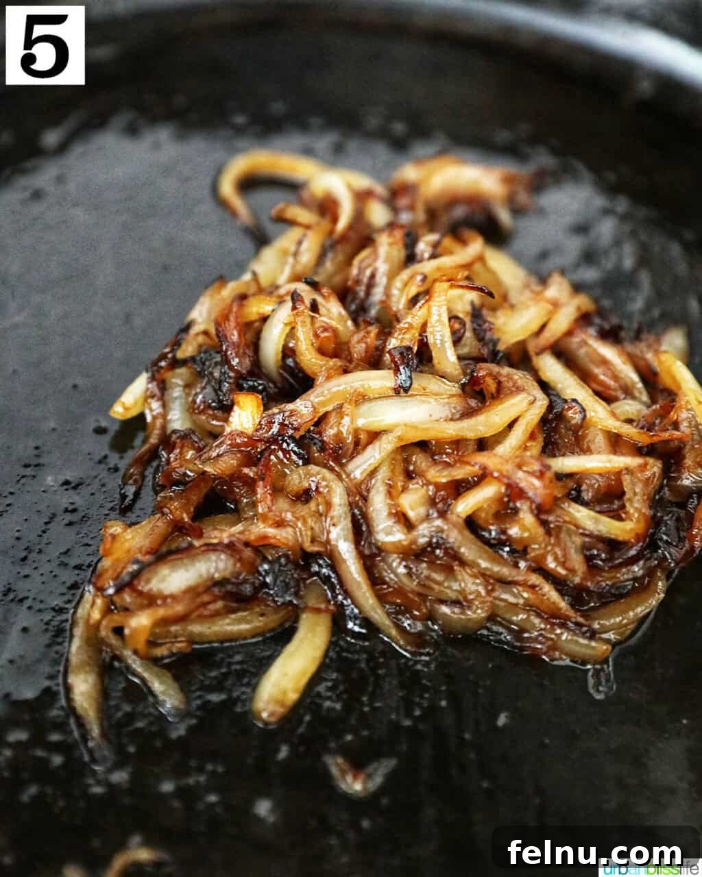 Savory Mushroom Toasts 9 Perfectly golden-brown and soft caramelized onions in a cast iron skillet, ready for use.