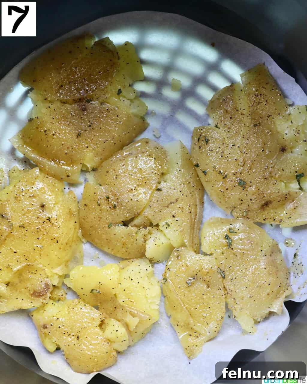 Crispy Air-Fried Smashed Potatoes 13 Raw, smashed potatoes neatly arranged in a single layer inside an air fryer basket, ready for cooking.
