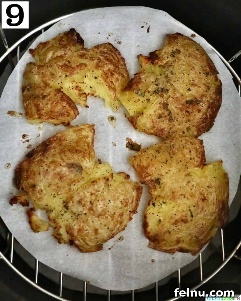 Crispy Air-Fried Smashed Potatoes 15 Four perfectly cooked, golden-brown smashed potatoes resting in an air fryer basket after cooking.