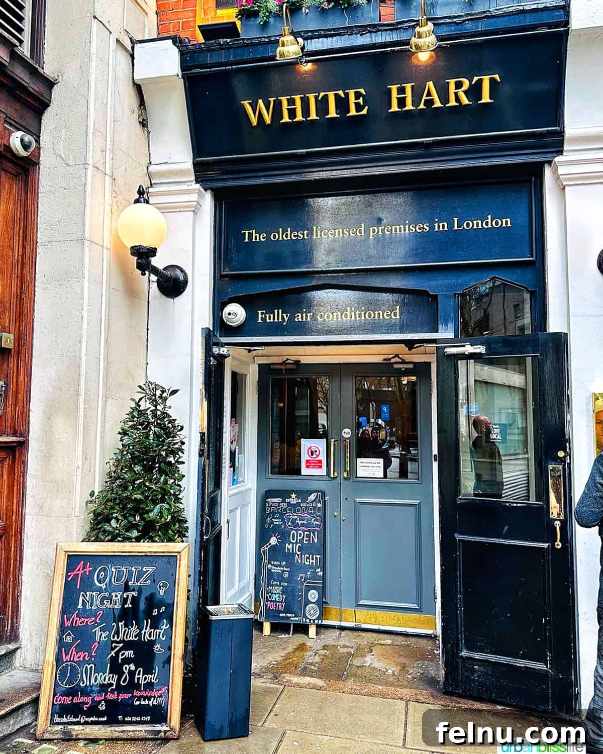 London's Culinary Gems 3 The charming exterior of a traditional British pub, The White Hart, with its classic architecture and inviting atmosphere.