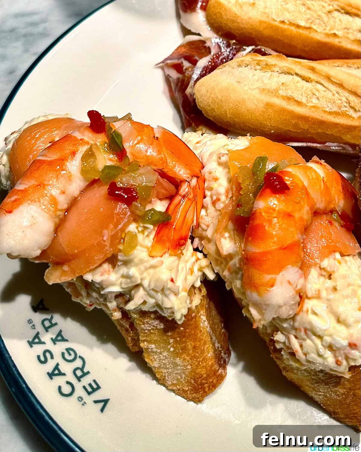 12 Essential Pintxos to Taste 13 A delicious Pintxo de Txaka featuring a creamy surimi salad topped with fresh prawns on a slice of bread at Casa Vergara in San Sebastian.