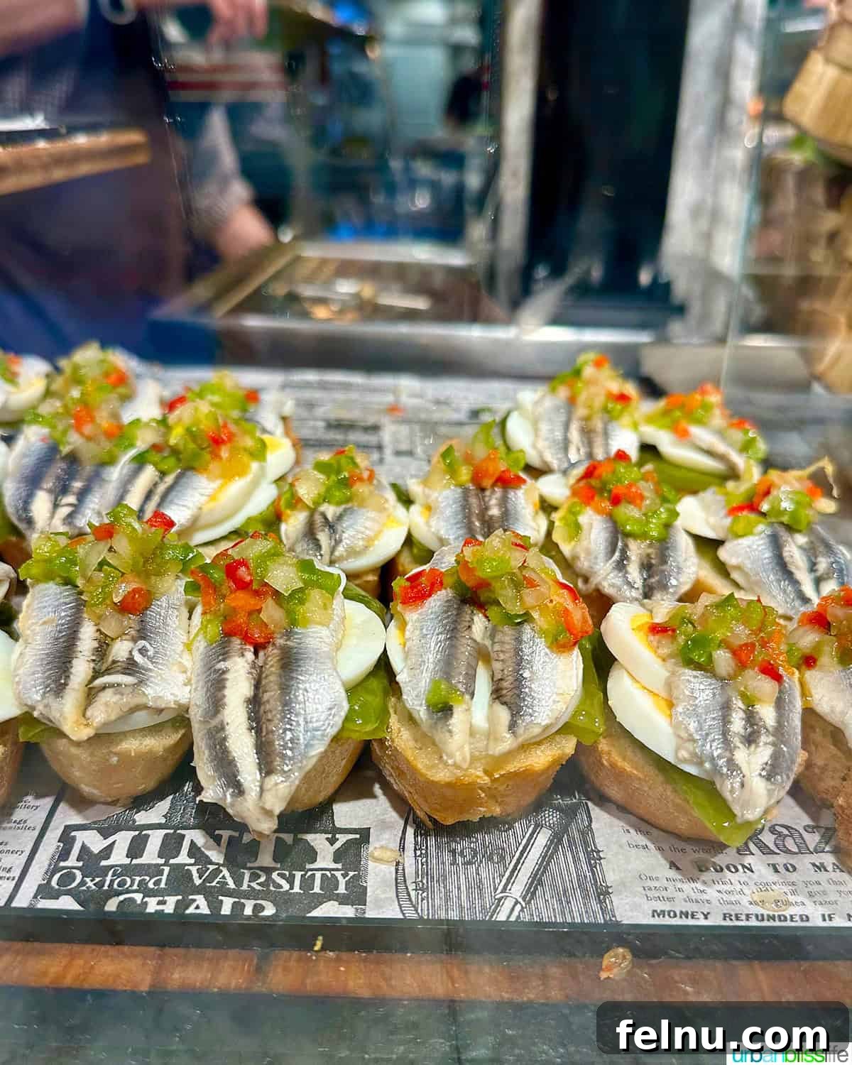 12 Essential Pintxos to Taste 10 Boqueron pintxos: cured white anchovies topped with red peppers, served on a slice of hard-boiled egg and bread.