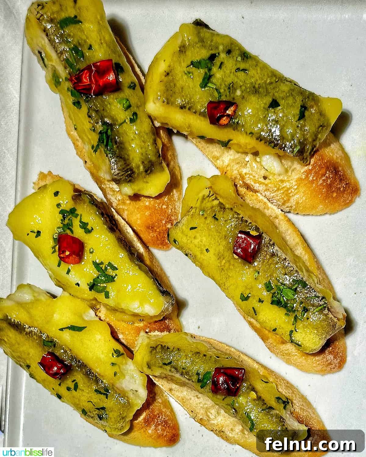 The Ultimate Pintxo Crawl: Bilbao's Best Bites 6 Cod in pil pil sauce pintxos served on a white plate, showcasing the rich and flavorful Basque sauce.