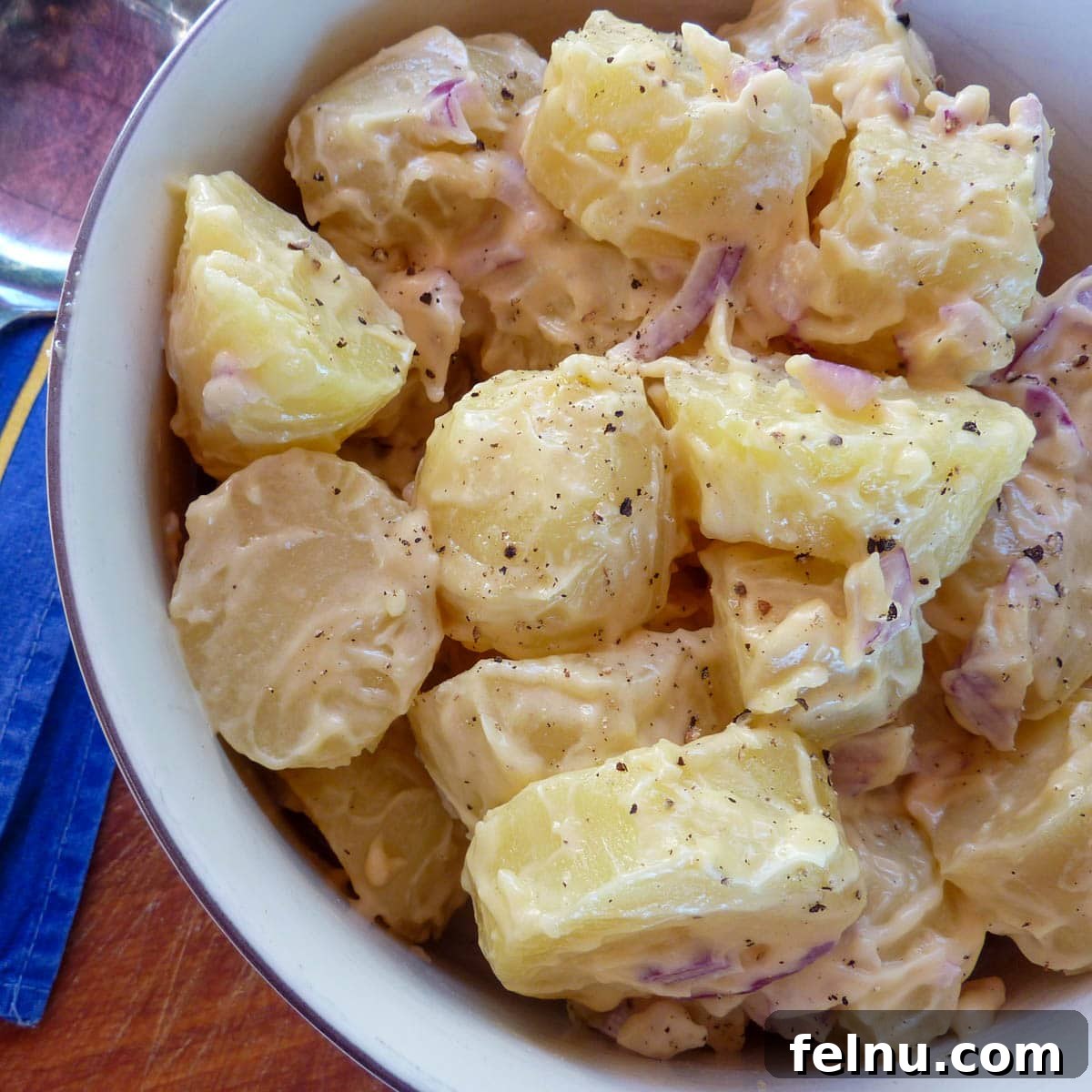 Creamy potato salad with mayonnaise, red onions, and mustard