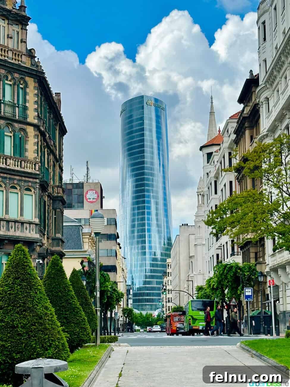Bilbao Unveiled: Exploring Spain's Basque Masterpiece 15 A modern skyscraper standing tall amidst other buildings in Bilbao, Spain, symbolizing the city's blend of old and new architecture.