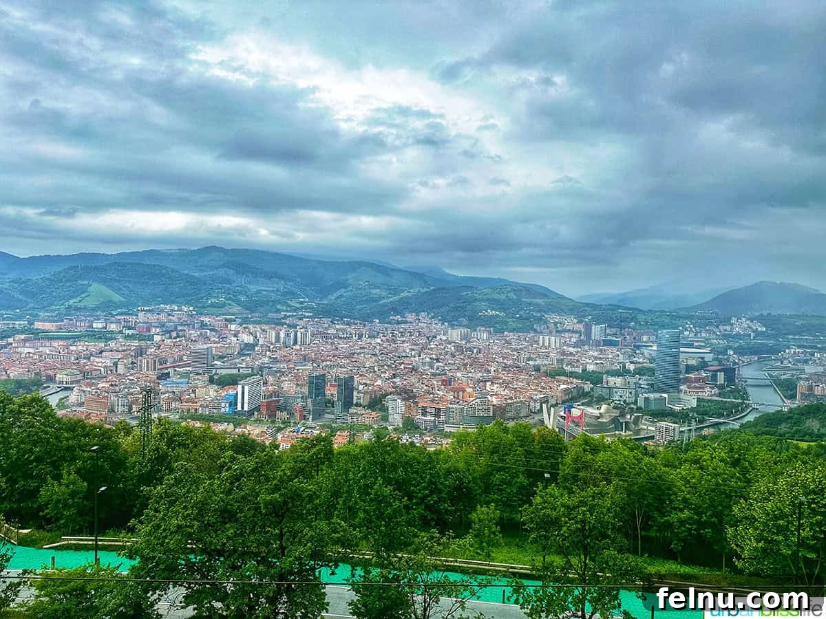 Bilbao Unveiled: Exploring Spain's Basque Masterpiece 3 Elevated mountain view overlooking the sprawling city of Bilbao, Spain, showcasing its urban landscape and surrounding hills.