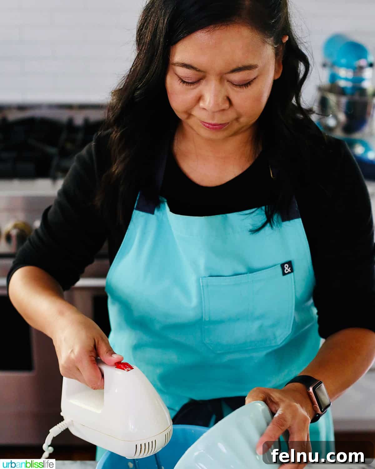 Large-Scale Baking: Recipes for a Crowd 4 Marlynn in an aqua apron baking, smiling.
