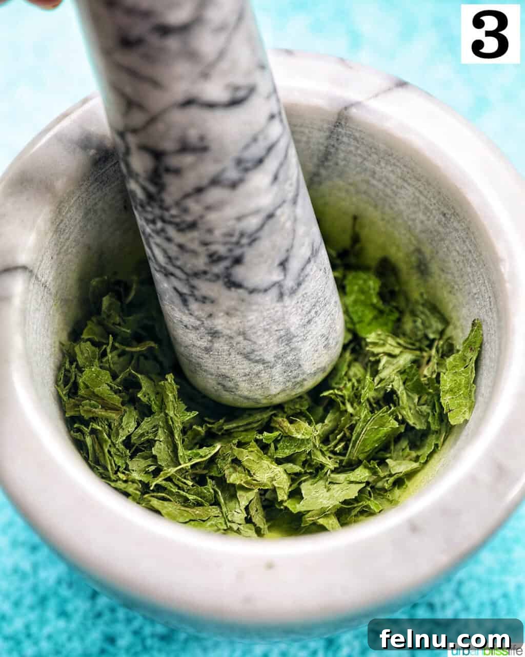 Mortar and pestle crushing dried mint leaves