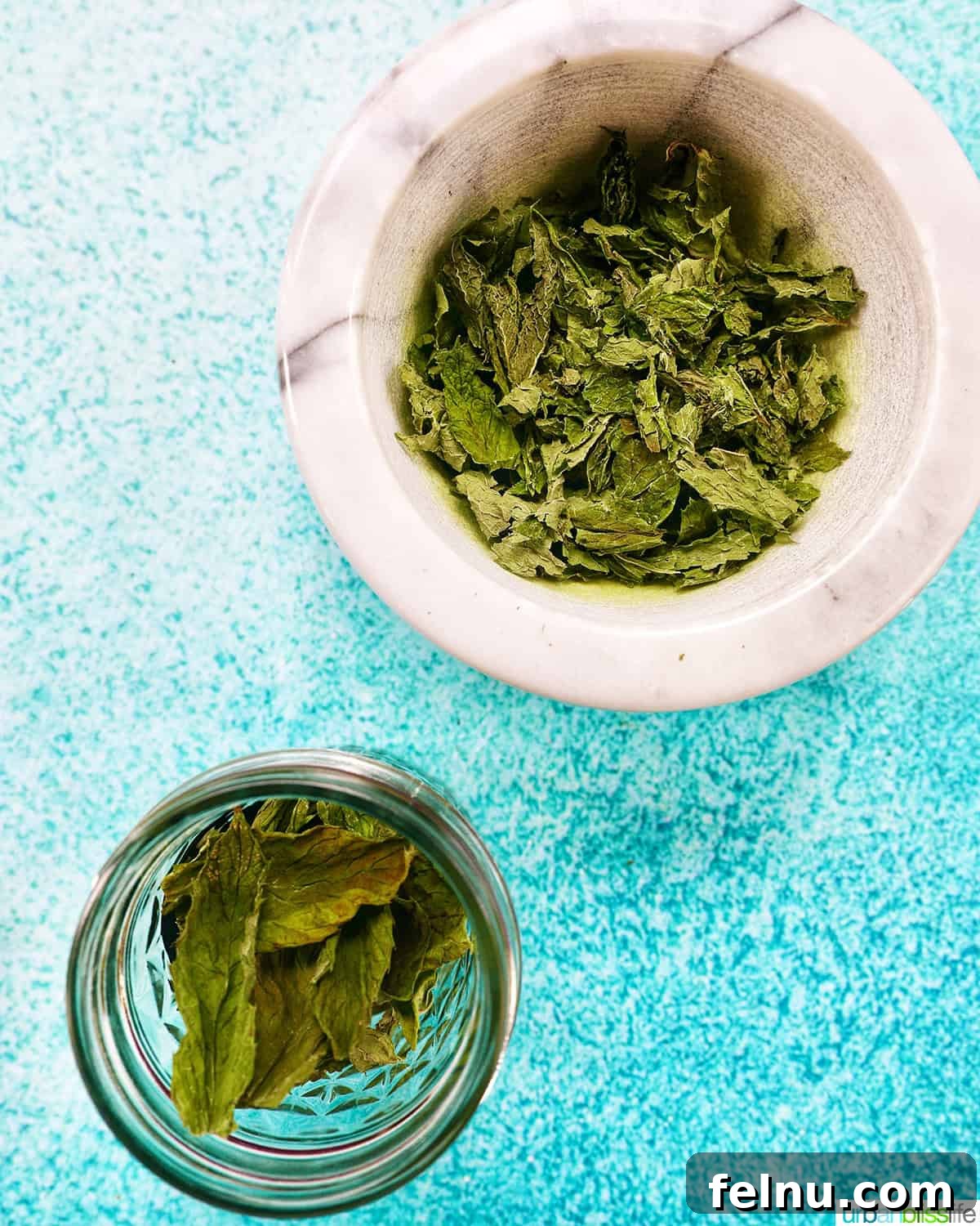 Dried mint leaves and crushed dried mint leaves in bowls