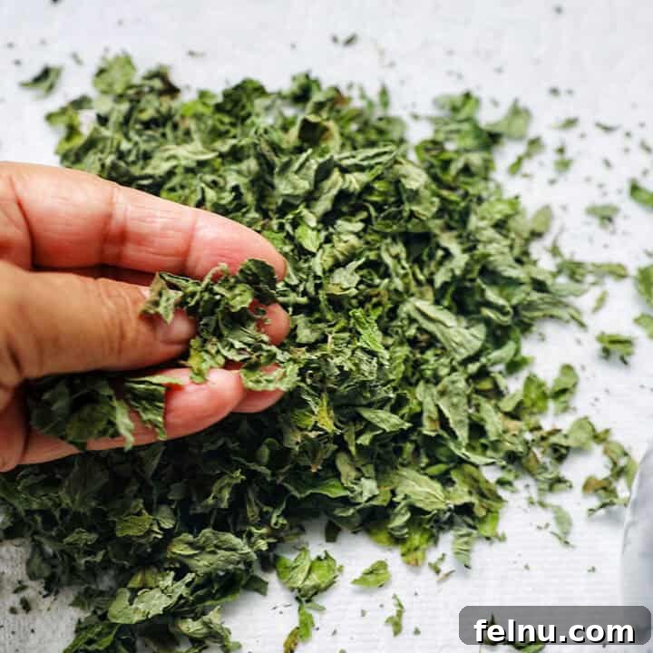 How to Dry Oregano at Home 16 hand crumbling dried oregano leaves.