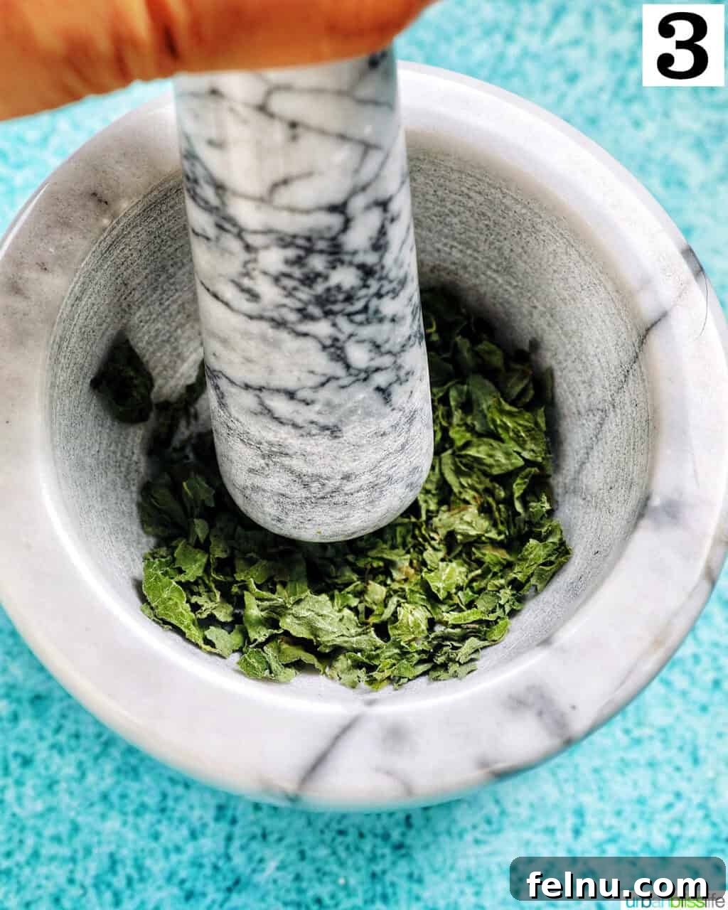 How to Dry Oregano at Home 8 dried oregano leaves being crushed in a marble bowl.